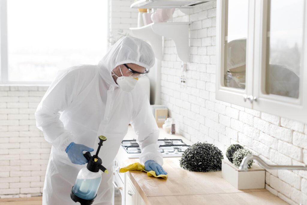 medium-shot-man-disinfecting-countertop-min